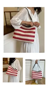 Détail du sac cabas en paille à rayures rouges et blanches avec anses en cuir noir