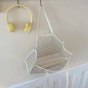 Large transparent jelly tote bag with M-letter print and white inner pouch hanging