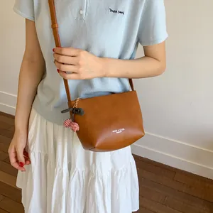 Minimalist brown leather small square crossbody bag with cherry charm accessory