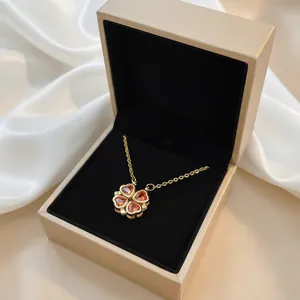 Detail of clover necklace with amber heart zircons in a golden jewelry box