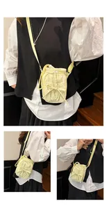 Detail van gele crossbodytas met trekkoord, strikdetail en verstelbare riem