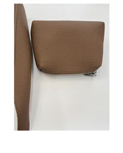 Détail de la texture cuir grainé marron et fermeture éclair argentée du sac seau