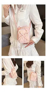 Detail van de lichtroze crossbody telefoontas met strik en trekkoord ontwerp