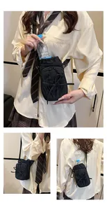 Detail van zwarte nylon crossbodytas met trekkoord bidonhouder en strikdecoratie