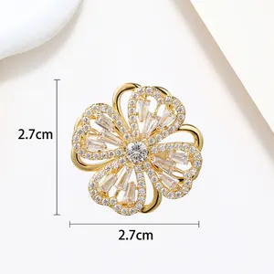 Close-up of 2.7cm gold flower brooch with white zircons and square cut stones