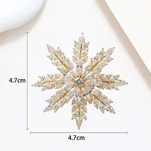 Detailed macro view of a 4.7cm gold snowflake brooch with sparkling marquise zirconia