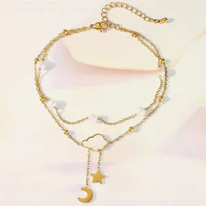 Detail of gold double-layer anklet featuring cloud, star, and moon charms with pearls