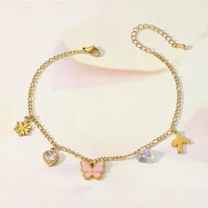 Detailed view of gold anklet featuring heart, butterfly, and bird charms with crystals