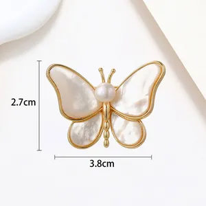 Detailed view of butterfly brooch with pearl inlay and dimensions 3.8cm by 2.7cm