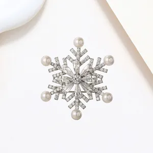 Elegant rotating snowflake brooch with silver plating, sparkling zircons and white pearls