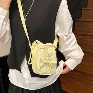 Lichtgele crossbody telefoontas met trekkoordsluiting en stijlvol strikdetail