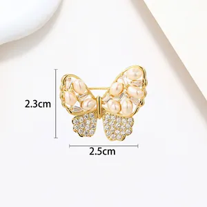 Detailed close-up of golden butterfly brooch with white pearls and crystals, size 2.3x2.5cm
