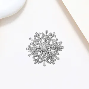Detail of silver snowflake brooch featuring micro-pave zircons and baguette cut gems