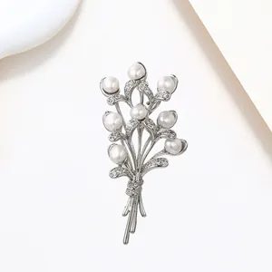 Detailed macro view of an elegant floral bouquet brooch with pearls and shimmering crystals