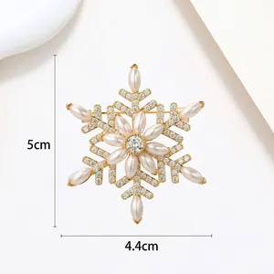 Detail view of a 5cm rotating snowflake brooch with pearls and crystals in gold finish