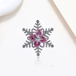 Close-up of snowflake brooch with pink heart-shaped crystals and sparkling zircon details