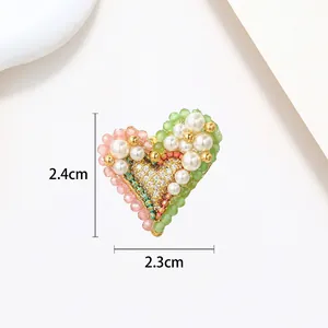 Macro view of heart-shaped pearl brooch with dimension details 2.4cm by 2.3cm