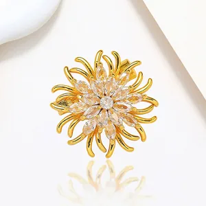 Close-up of golden spinning snowflake brooch with marquise stones and crystal details
