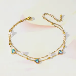 Detail of double-layer gold anklet featuring pearl accents and purple heart charms
