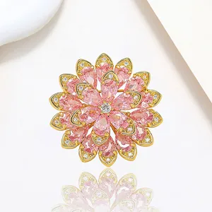 Macro view of crystal flower brooch with pink teardrop petals and gold metal base