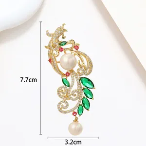 Detailed view of phoenix pearl brooch with crystal zircon inlay and gold finish