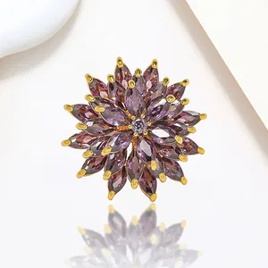Macro shot of rotating purple flower brooch with marquise-cut gems and golden base