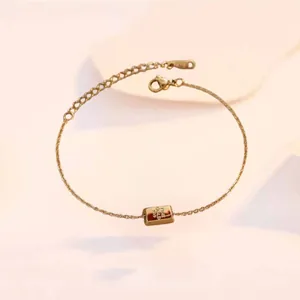 Detail of the lobster clasp and fine gold 999 engraving on a minimalist gold heart anklet