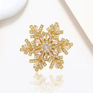 Macro detail of rotating snowflake brooch with gold plating and sparkling white crystals