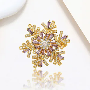 Detail of spinning snowflake brooch with purple baguette stones and gold finish