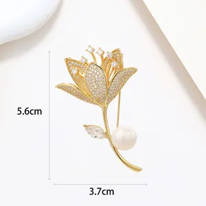 Detailed view of a 5.6cm gold flower brooch with white pearl and sparkling crystals