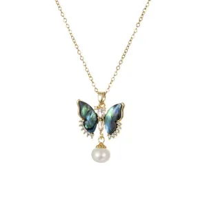Collar dorado con colgante de mariposa de nácar irisado y una perla blanca colgante