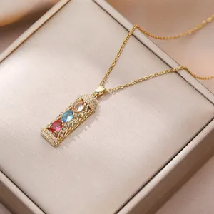 Macro shot of a gold bamboo-style pendant with colorful gemstones and small cubic zirconia