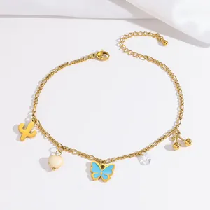 Detailaufnahme einer goldenen Fußkette mit Anhängern aus Herz, Schmetterling und Kirsche