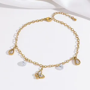 Detailaufnahme der Gold-Fußkette mit Kristalltropfen und einem Pavé-Schmetterlingsanhänger