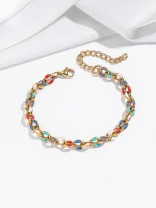 Détail d'un bracelet en acier doré avec maillons en émail coloré et fermoir mousqueton