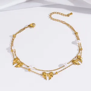 Detailansicht der goldenen mehrlagigen Fußkette mit Schmetterlingen und Perlen