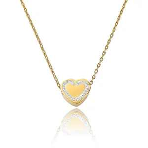 Détail macro d'un collier cœur doré orné d'un anneau extérieur en cristaux brillants