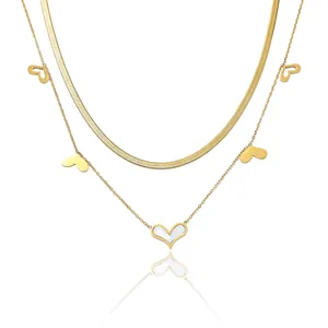 Vue détaillée du collier doré double rang avec pendentifs cœur et inserts en nacre