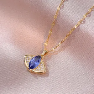 Collier en or avec pendentif gemme bleue taille marquise sur fond de soie rose