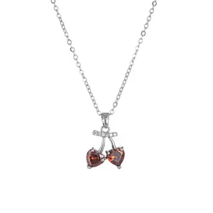 Minimalist silver chain necklace with red heart-shaped cherry pendant and small crystals