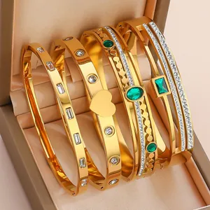 Detail of four gold-plated stainless steel bracelets with emerald stones and cubic zirconia