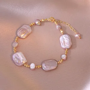 Dettaglio bracciale con perle barocche viola e perle dorate su seta rosa