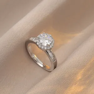 Sparkling silver halo ring with a 1-carat round center stone and side baguette diamonds