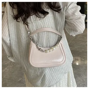 Détail du sac en cuir brillant rose avec chaîne argentée et perles blanches