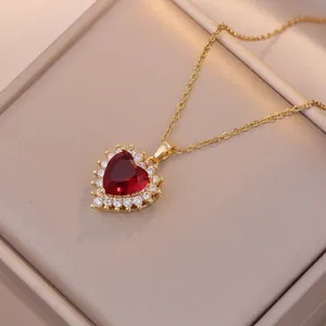 Elegante collana a cuore dorata con grande pietra rossa e alone di diamanti scintillanti