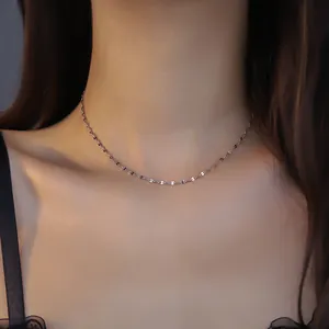 Close-up of a delicate 18K stainless steel chain necklace on a model's neck