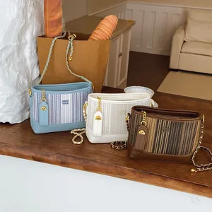 Fashionable women's tote chain bag in blue and beige with a metallic puppy charm