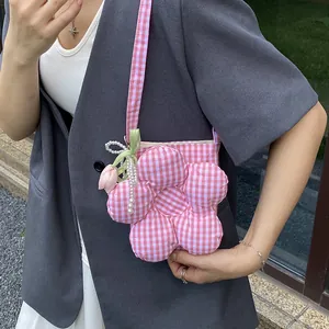 Pink checkered flower-shaped canvas crossbody bag with pearl tulip charms worn by model