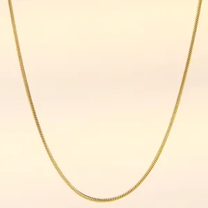 Macro detail of 18K gold-plated stainless steel snake chain with a smooth glossy finish
