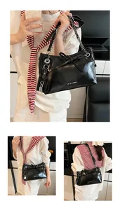 Detail of glossy black bow shoulder bag with silver chain strap and metal lock charm